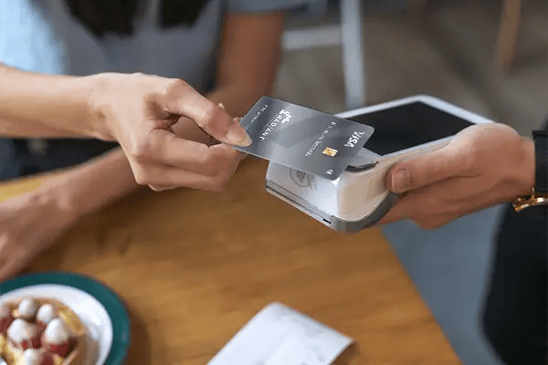 Person tapping a Radiant Credit Union Platinum rewards Visa credit card for fast, secure contactless payment.