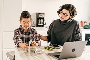 Parent and child exploring Radiant Credit Union savings opportunities at home to start building future savings.